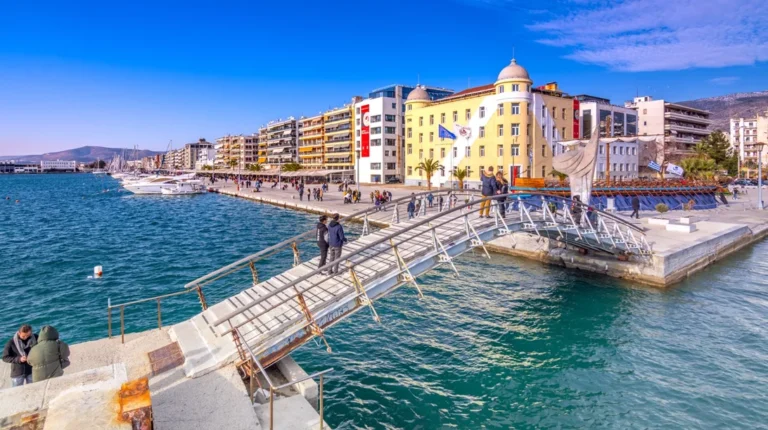 Παραλιακή πεζογέφυρα στον Βόλο με φόντο την πόλη και το λιμάνι