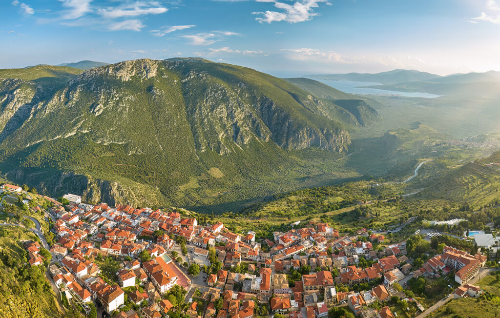 εστιατόρια στους Δελφούς Πανοραμική θέα των Δελφών με τα κόκκινα κεραμίδια και τον Παρνασσό στο φόντο.