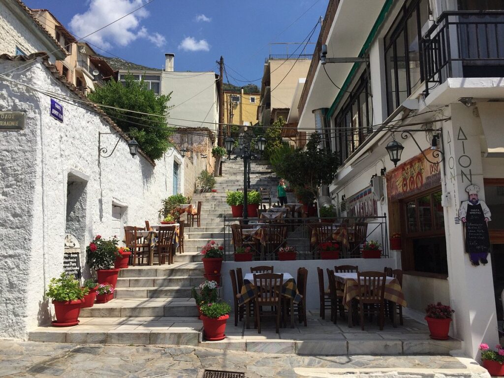 Παραδοσιακή ταβέρνα στα σκαλιά των Δελφών με τραπεζάκια έξω και καρό τραπεζομάντηλα.