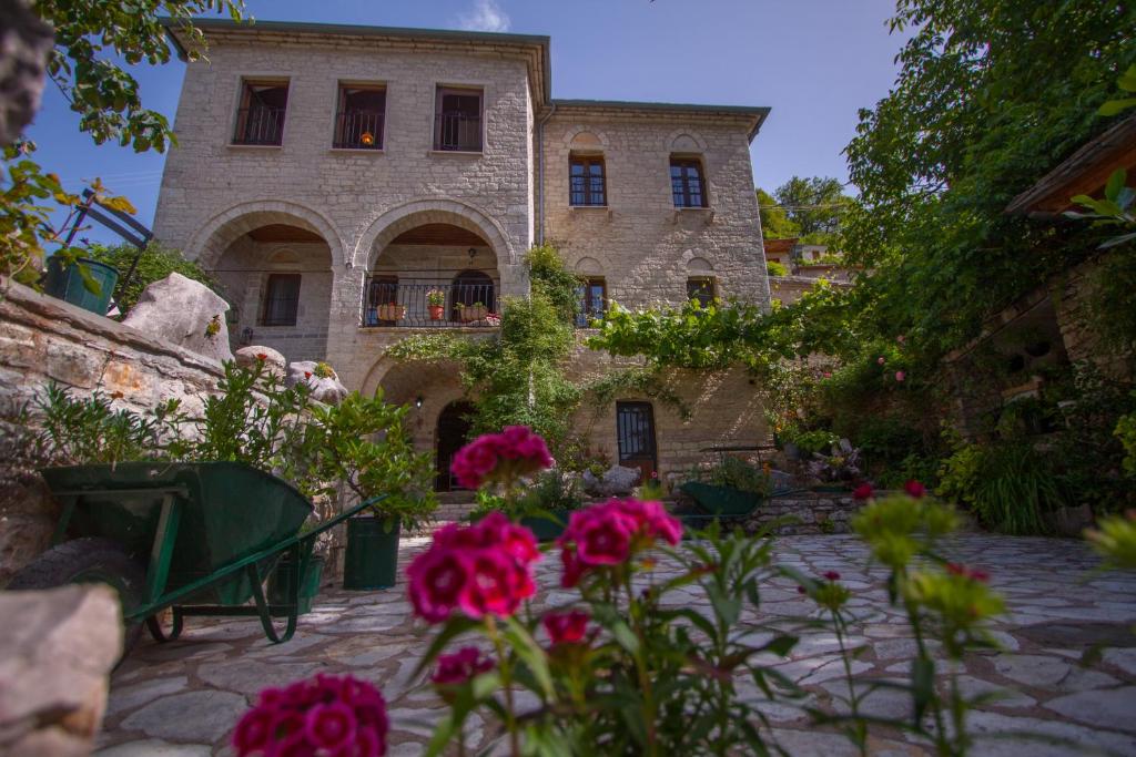Αυλή με λουλούδια και παραδοσιακό πετρόχτιστο αρχοντικό — δείγμα από τα καλύτερα ξενοδοχεία στον Νομό Ιωαννίνων