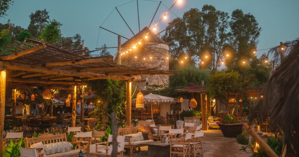 Εξωτερικός χώρος bar με ανεμόμυλο και διακόσμηση με φώτα – Καλύτερα bar στην Κω