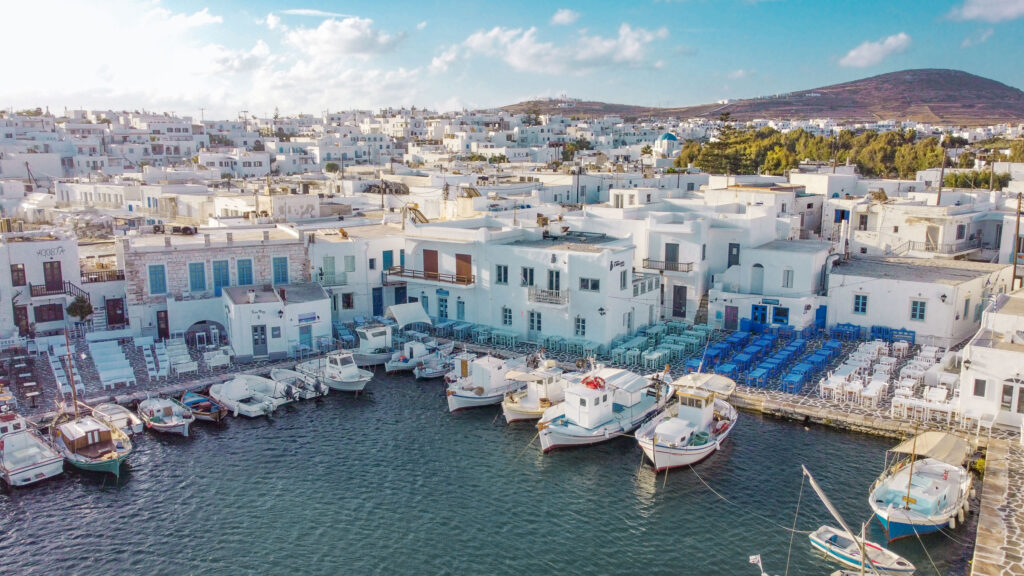 Παραδοσιακά καΐκια και λευκά σπίτια στο γραφικό λιμανάκι της Νάουσας – ιδανικό σκηνικό για ένα ταξίδι στην Πάρο