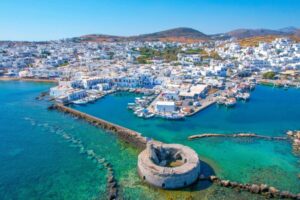 ανοραμική θέα του λιμανιού της Νάουσας στην Πάρο με το ενετικό κάστρο και γαλαζοπράσινα νερά