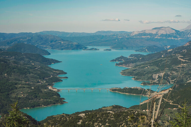 Πανοραμική θέα της Τεχνητής Λίμνης Κρεμαστών με γαλάζια νερά και τη γέφυρα της Επισκοπής